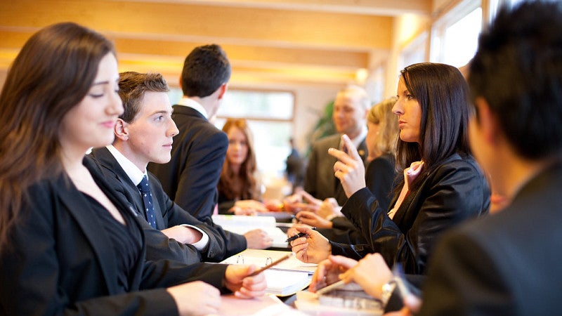 A group of people wearing suits at a conference table.