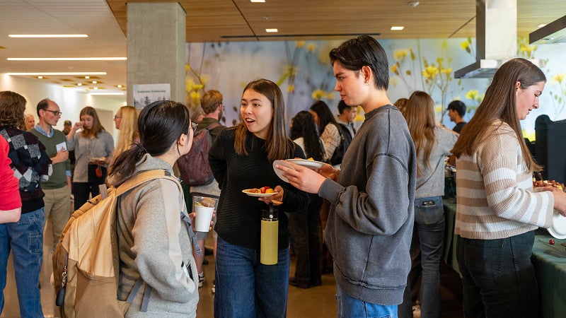 Students talking in groups within a crowd