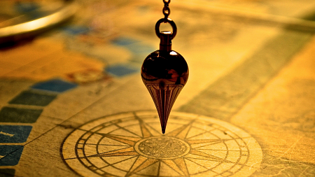 Maritime navigation weight hanging over a compass symbol on a map.