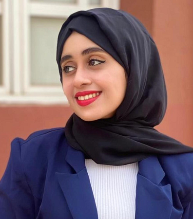 Portrait of Maryam al-Ojel with head turned to the left and looking left.  She wears a traditional head covering.