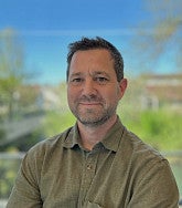 Karl Reasoner has short hair and stubble