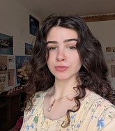 Claire Geisler has long curly dark brown hair