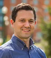 Karl Reasoner has short hair and a blue shirt