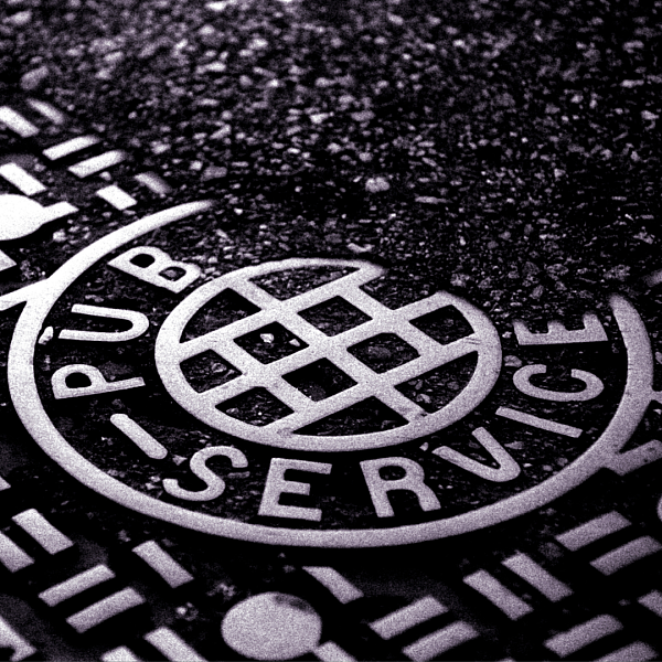 Manhole cover with the words Public Service.