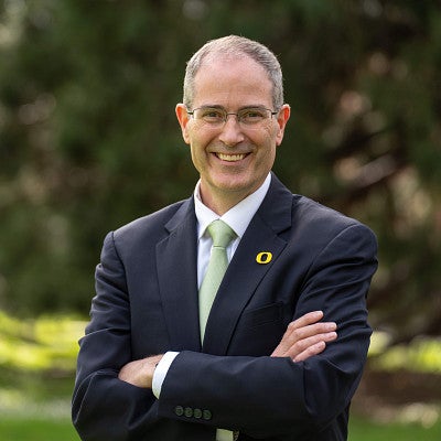 Provost Chris Long smiling with arms folded