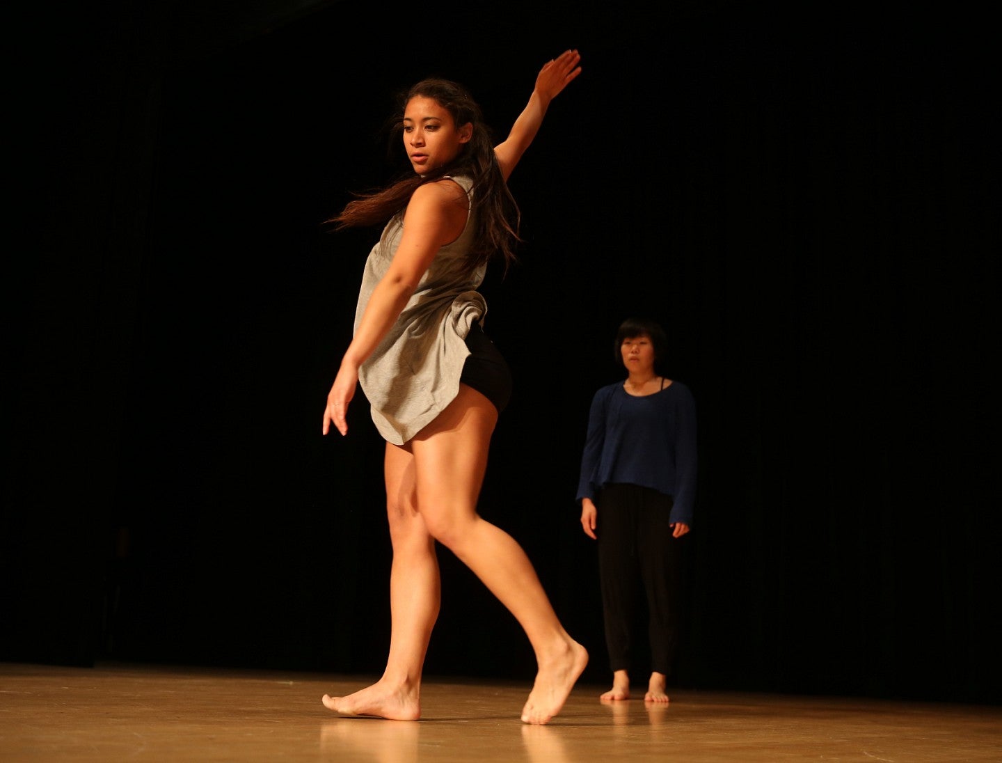 woman dances against dark background