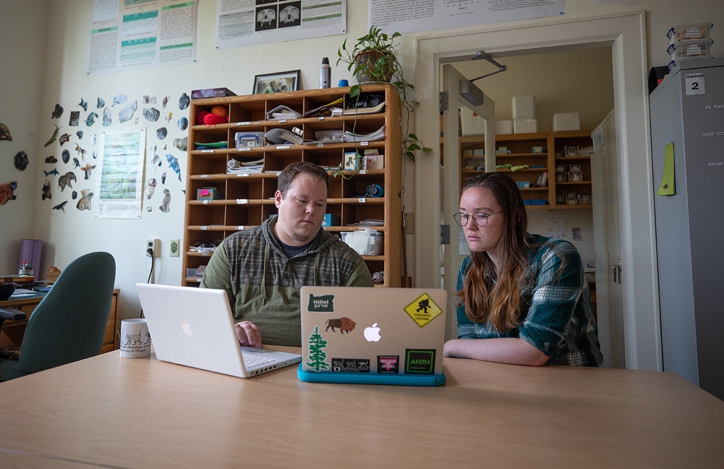 Two researchers examining data on laptop computers